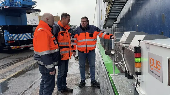 Eine Person arbeitet an der Landstrom Verbindung zu einem Schiff